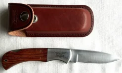 Tradera Knivar & Svärd<Fällkniv Fenwick med träskaft och läderfodral i nyskick.