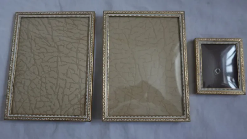 Tradera Gamla fotoramar guld o vitt med vackert mönster ram metall lätt kupat glas Jyden> Ramar