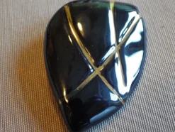 Tradera Broscher<Äldre vacker Brosch i glaserad porslin, svart med gulddekor. 50-tal