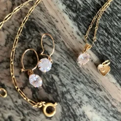 Tradera Smyckespaket<Tunn guldkedja med hänge, två örhängen samt ett extra hänge hjärta.