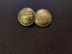 Tradera Järn- & Spårvägsmemorabilia<Två antika knappar med lokmotiv