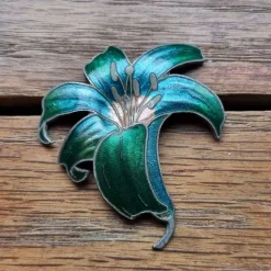 Tradera Broscher<Vacker brosch vitmetall grön blå emalj blomma orkidé